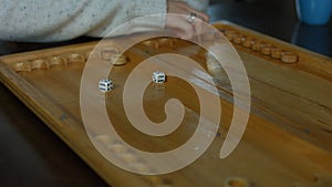 Playing backgammon on a wooden table with dice