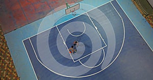 Playing basketball on the outside court. Two players doing sports practicing with the ball. Dribbling a basketball