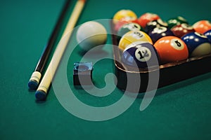 Playing billiard. Billiards balls and cue on green billiards table. Billiard sport concept.