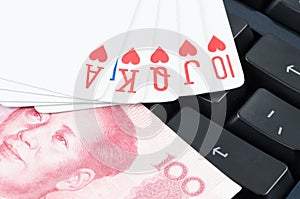 Playing card and Chinese yuan on the computer keyboard