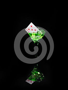 Playing card in a cocktail glass on black background. casino series