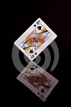 Playing card, queen of spades on a black background