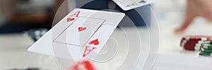 Playing cards aces and dice flying over gaming table in casino closeup