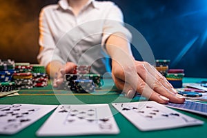 Playing cards in a casino. A lot of chips, money. A player in a casino makes bets. Poker