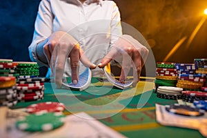 Playing cards in a casino. A lot of chips, money. A player in a casino makes bets. Poker