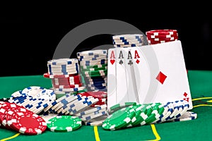 Playing cards and casino poker chips on green desk