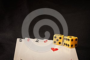 Playing cards and dice on black background
