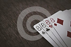 Playing cards four eights closeup on a wooden table.