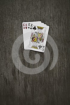 Playing cards four kings. wooden background. game abstract.