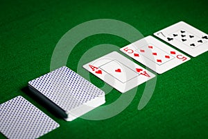 Playing cards on green table surface