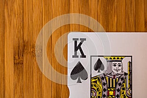 Playing cards king card close up, isolated on wooden table. Casino concept, risk, chance, good luck or gambling