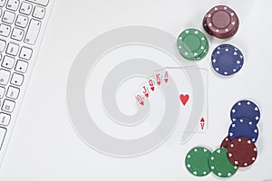 Playing cards next to poker chips and keyboard