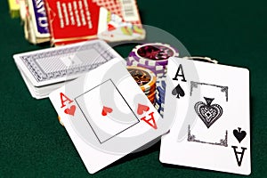 Playing cards and poker chips on agreen table. Stack of chips for poker