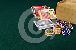 Playing cards and poker chips on agreen table. Stack of chips for poker