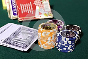 Playing cards and poker chips on agreen table. Stack of chips for poker