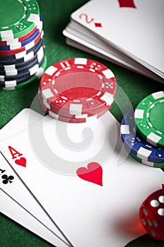 Playing cards, poker chips, and dices on green table