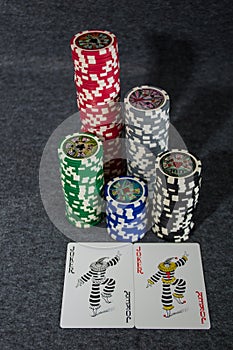 Playing cards and poker chips on grey background