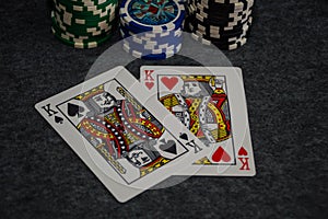 Playing cards and poker chips on grey background