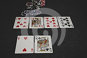 Playing cards and poker chips on grey background