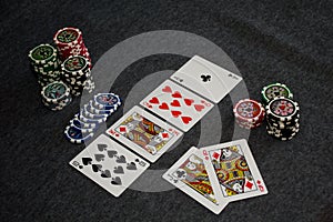 Playing cards and poker chips on grey background