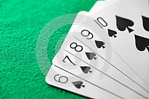 Playing cards, poker combination straight flush of black suit of spades from ten