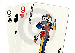 Playing cards showing a joker and a pair of nines.