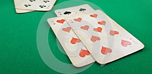 Playing cards ten and nine of hearts lay on green table