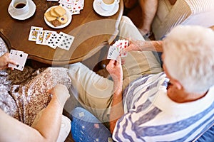 Playing the cards theyre dealt. High angle shot of a group of seniors playing cards around a table in their retirement