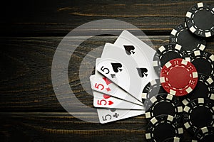 Playing cards with a winning combination of four of a kind or quads on a dark vintage table in a poker club. Winning in sports