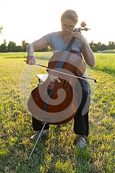 Playing the cello on the meadow