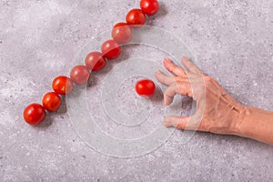 Playing with cherry tomatoes for accuracy on the table. Womans hand and cherry tomatoes