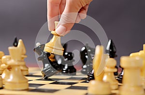 Playing chess. White queen Hitting the black one in front of the rest figures