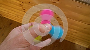 Playing with the colorful Fidget Spinner. Toy spinner in hand