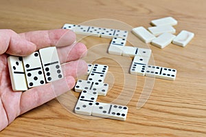 Playing dominoes on a wooden table. Dominoes game concept