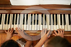 Playing a duet. High angle view of two little girls playing a duet on the piano.