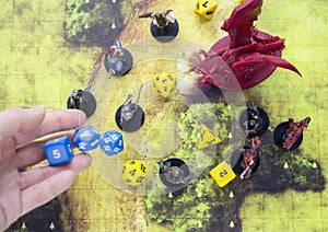 Playing dungeons and dragons game. Map with a figure of dragon and plastic figures of rpg characte