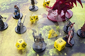 Playing dungeons and dragons game. Map with a figure of dragon and plastic figures of rpg characters