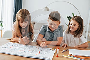 Playing game together. Kids having fun in the domestic room at daytime