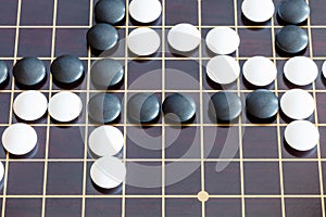 Playing in Go game on wooden board