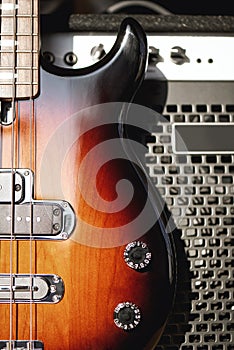 Playing guitar...Close up photo of a brown electric guitar with volume and tone control knobs and amplifier