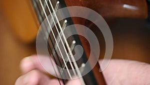 Playing guitar close-up of strings and fingers