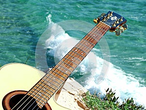 Playing guitar looking the sea