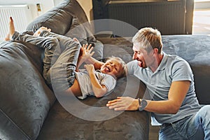 Playing and having fun. Father and son is indoors at home together