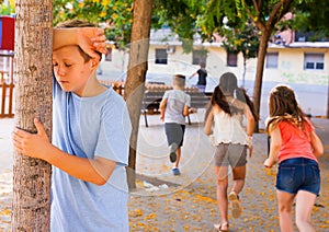 Playing hide and seek. boy closed eyes his hands photo