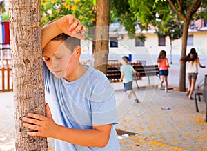 Playing hide and seek. boy closed eyes his hands photo