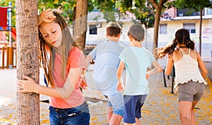 Playing hide and seek. Girl covering eyes her hands photo