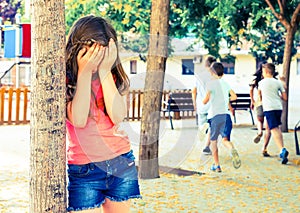 Playing hide and seek. Girl covering eyes her hands photo