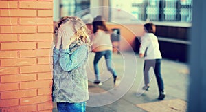 Playing hide and seek. Girl covering eyes her hands standing photo