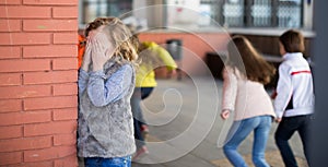 Playing hide and seek. Girl covering eyes her hands standing at photo