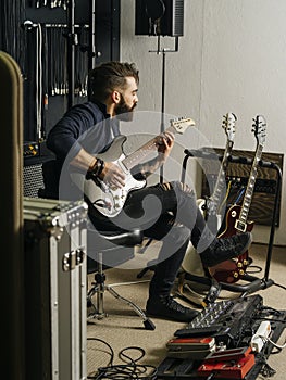 Playing his electric guitar in the recording studio